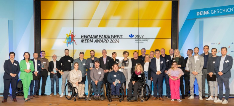 Abschlussfoto der GPMA-Preisverleihung mit allen Nominierten, Preisträgerinnen und Preisträgern, Laudatorinnen und Laudatoren und Moderatorin Ninia LaGrande.
© DGUV / Wolfgang Bellwinkel