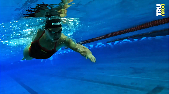 Das Bild zeigt die Schwimmerin Gina im Schwimmbecken von unten